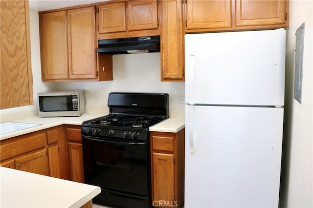 80 Greenmoor Unit 40, Irvine, CA 92614 - kitchen featuring freestanding refrigerator, black gas stove, under cabinet range hood, stainless steel microwave, and light countertops