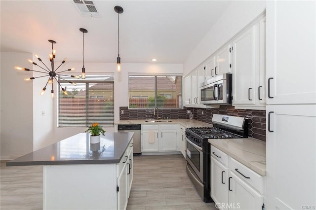 38742 Berrycreek Ct, Palmdale, CA 93551 - kitchen with stainless steel appliances, a chandelier, tasteful backsplash, white cabinets, and a center island