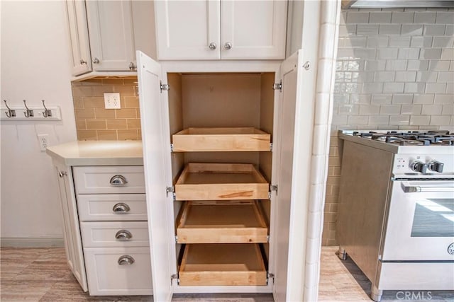 1911 Pepper Dr, Altadena, CA 91001 - kitchen view of gas stove, tasteful backsplash, white cabinetry, and light countertops