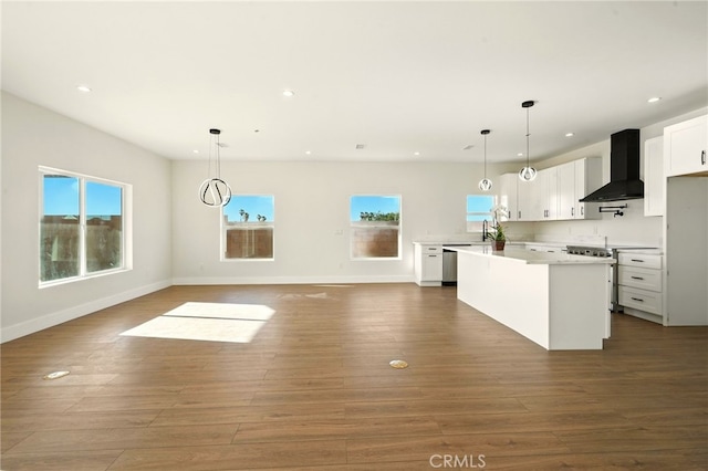 36733 42nd St E, Palmdale, CA 93552 - kitchen with wall chimney exhaust hood, stainless steel appliances, a kitchen island, recessed lighting, and dark wood-type flooring