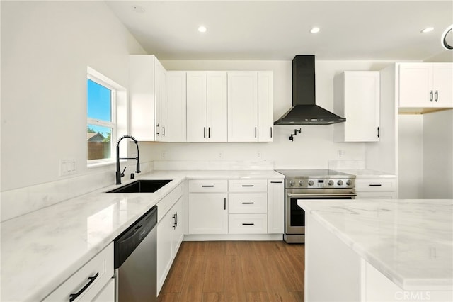36733 42nd St E, Palmdale, CA 93552 - kitchen featuring appliances with stainless steel finishes, wall chimney range hood, light stone countertops, wood finished floors, and white cabinets