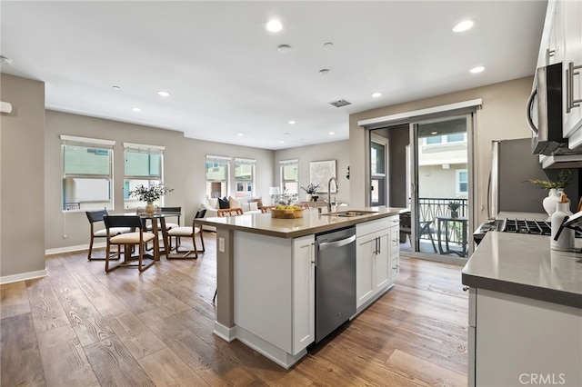 109 Alder Rdg, Lake Forest, CA 92610 - kitchen with appliances with stainless steel finishes, white cabinetry, light wood-style flooring, a center island with sink, and recessed lighting