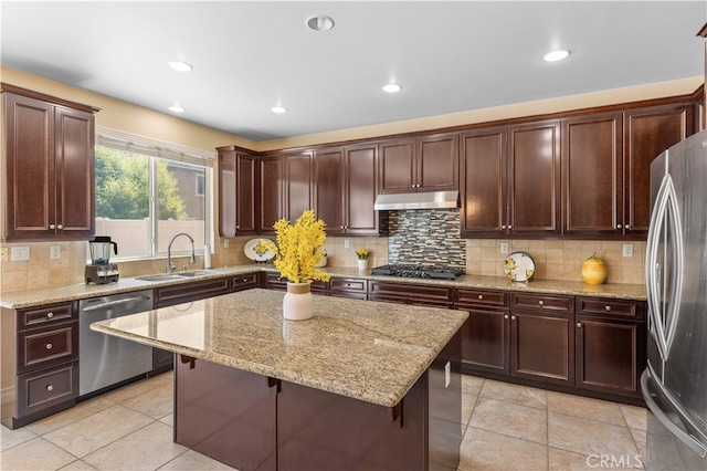 6585 Youngstown St, Chino, CA 91710 - kitchen featuring stainless steel appliances, under cabinet range hood, a center island, tasteful backsplash, and light stone counters