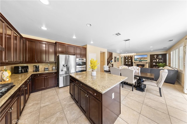 6585 Youngstown St, Chino, CA 91710 - kitchen with stainless steel refrigerator with ice dispenser, a kitchen island, backsplash, light stone countertops, and light tile patterned floors