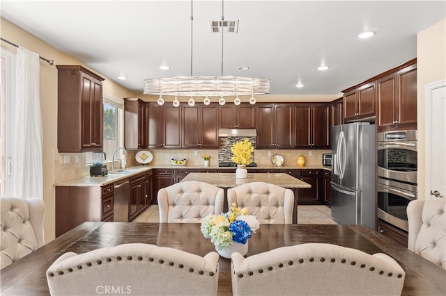 6585 Youngstown St, Chino, CA 91710 - kitchen with appliances with stainless steel finishes, dark brown cabinets, tasteful backsplash, light stone countertops, and recessed lighting