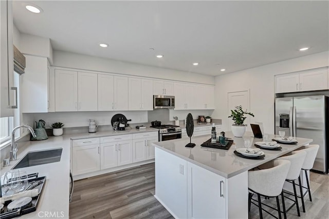 17148 Kent St, Hesperia, CA 92345 - kitchen featuring appliances with stainless steel finishes, a kitchen bar, white cabinetry, and recessed lighting