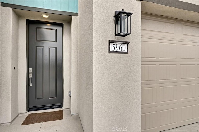 17148 Kent St, Hesperia, CA 92345 - doorway to property featuring a garage and stucco siding