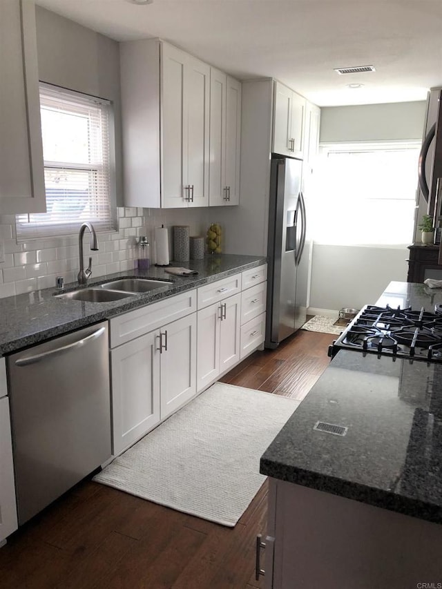 3732 Mira Pacific Dr, Oceanside, CA 92056 - kitchen with stainless steel appliances, dark wood-style floors, dark stone counters, white cabinets, and backsplash