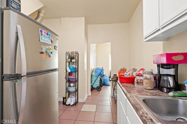 1148 E 43rd, Los Angeles, CA 90011 - kitchen featuring freestanding refrigerator, light tile patterned flooring, and white cabinetry