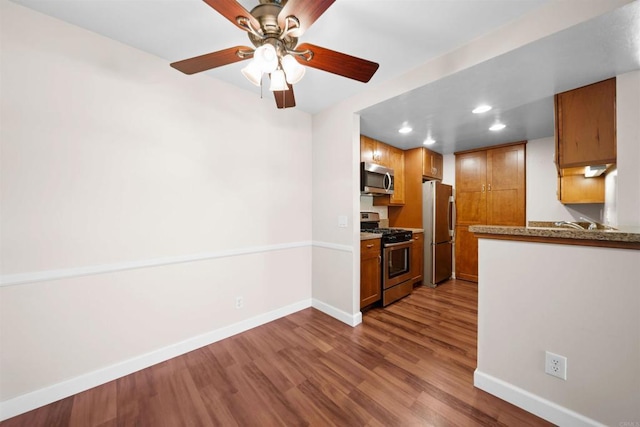 1087 Shadowridge Dr Unit 101, Vista, CA 92081 - kitchen featuring appliances with stainless steel finishes, dark wood finished floors, brown cabinetry, recessed lighting, and a ceiling fan