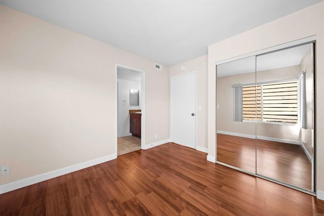 1087 Shadowridge Dr Unit 101, Vista, CA 92081 - unfurnished bedroom featuring a closet, wood finished floors, and ensuite bathroom