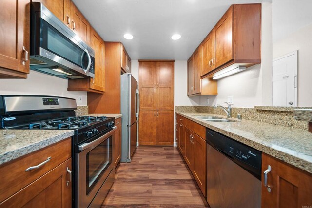 1087 Shadowridge Dr Unit 101, Vista, CA 92081 - kitchen featuring stainless steel appliances, dark wood-style floors, brown cabinetry, light stone countertops, and recessed lighting