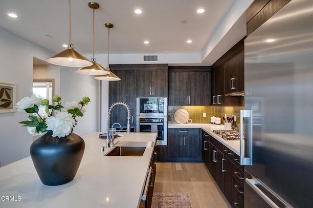 820 Mission St Unit 208, South Pasadena, CA 91030 - kitchen featuring appliances with stainless steel finishes, light countertops, dark brown cabinets, light wood-style flooring, and tasteful backsplash