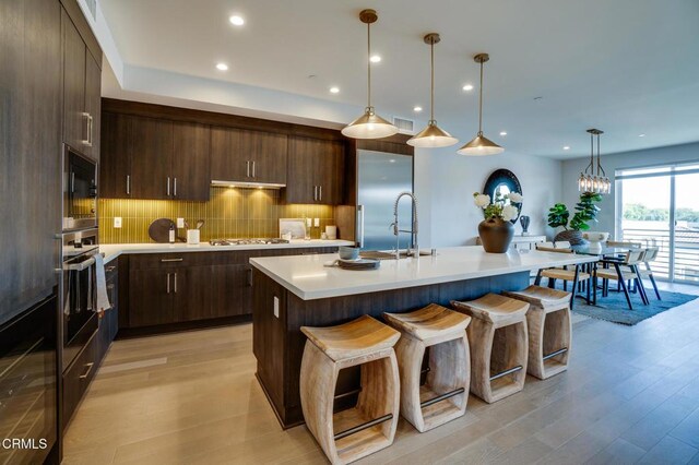 820 Mission St Unit 208, South Pasadena, CA 91030 - kitchen with appliances with stainless steel finishes, light countertops, dark brown cabinets, light wood-type flooring, and recessed lighting