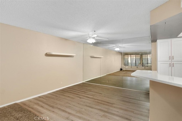43195 Andrade Ave Unit K, Hemet, CA 92544 - unfurnished living room featuring a ceiling fan, light wood-style flooring, and a textured ceiling