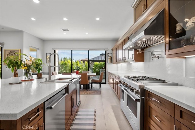 20720 W Liana Ct, Porter Ranch, CA 91326 - kitchen with appliances with stainless steel finishes, under cabinet range hood, recessed lighting, a large island with sink, and brown cabinets