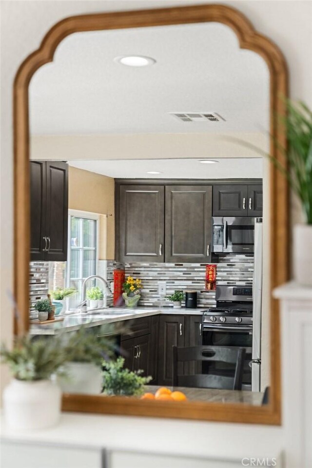 439 Acaso Dr, Walnut, CA 91789 - kitchen featuring stainless steel appliances, decorative backsplash, dark brown cabinets, and light countertops