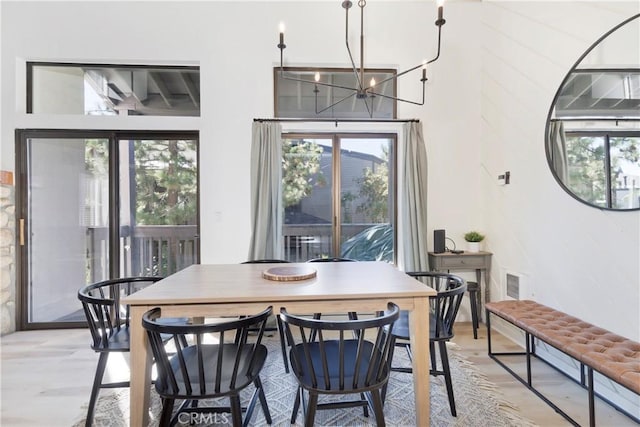 362 Old Mammoth Rd Unit 47, Mammoth Lakes, CA 93546 - dining room featuring a chandelier, light wood-type flooring, and a towering ceiling