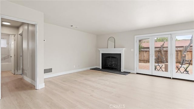 1466 Balboa St, San Luis Obispo, CA 93405 - unfurnished living room featuring light wood finished floors, a fireplace with raised hearth, and french doors