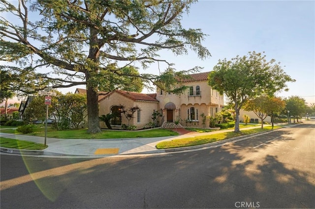 1161 N Everett St, Glendale, CA 91207 - mediterranean / spanish house featuring stucco siding, a tile roof, and a front lawn