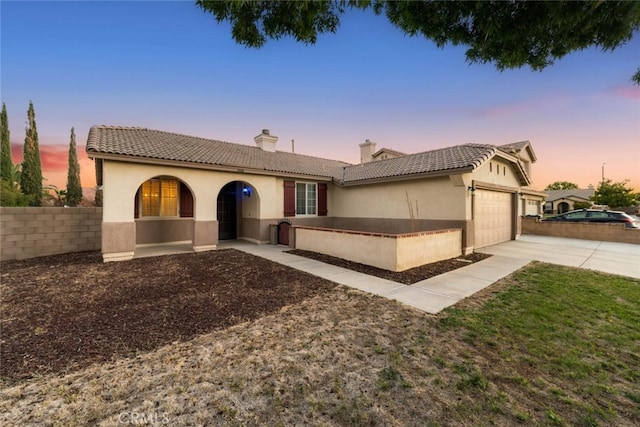 1706 Regents St, Lancaster, CA 93534 - view of front facade with an attached garage, a chimney, driveway, and stucco siding