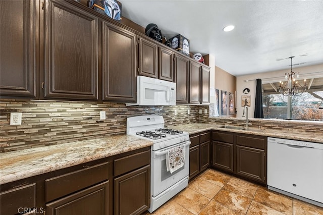 1706 Regents St, Lancaster, CA 93534 - kitchen featuring white appliances, backsplash, dark brown cabinetry, a chandelier, and light stone countertops