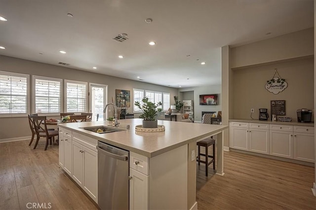 13471 Planet Ct, Riverside, CA 92503 - kitchen with dishwasher, recessed lighting, light wood-type flooring, a kitchen island with sink, and white cabinets