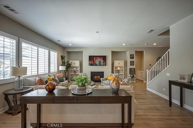 13471 Planet Ct, Riverside, CA 92503 - living area featuring plenty of natural light, wood finished floors, a glass covered fireplace, stairs, and recessed lighting
