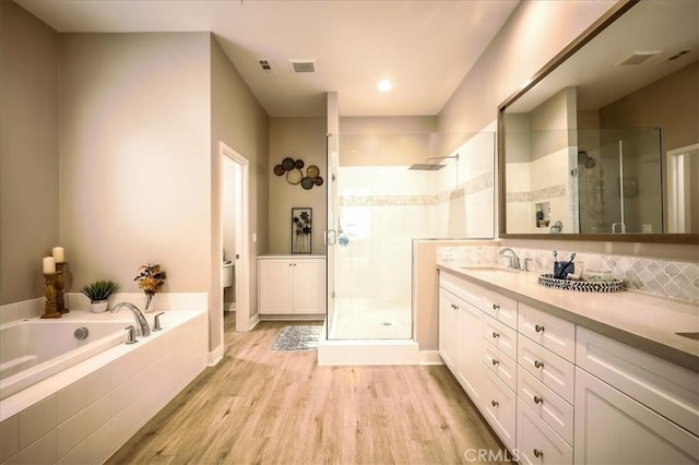 13471 Planet Ct, Riverside, CA 92503 - bathroom featuring a stall shower, double vanity, wood finished floors, and a bath