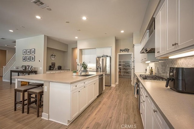 13471 Planet Ct, Riverside, CA 92503 - kitchen with extractor fan, appliances with stainless steel finishes, tasteful backsplash, light wood finished floors, and recessed lighting