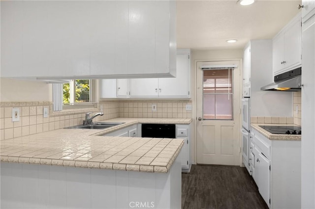 17342 Almelo Ln, Huntington Beach, CA 92649 - kitchen featuring black appliances, under cabinet range hood, white cabinets, a peninsula, and tasteful backsplash
