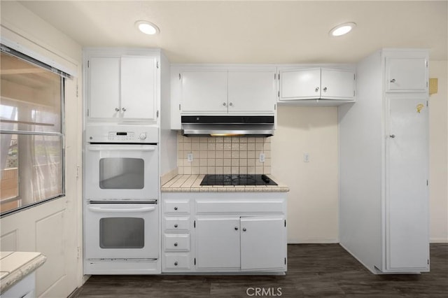 17342 Almelo Ln, Huntington Beach, CA 92649 - kitchen with double oven, black electric stovetop, under cabinet range hood, white cabinetry, and recessed lighting