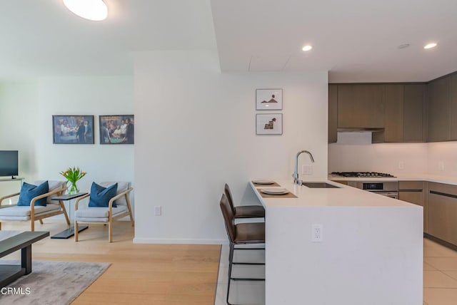 889 Francisco St Unit 802, Los Angeles, CA 90017 - kitchen with a peninsula, light countertops, stainless steel gas stovetop, modern cabinets, and a breakfast bar area