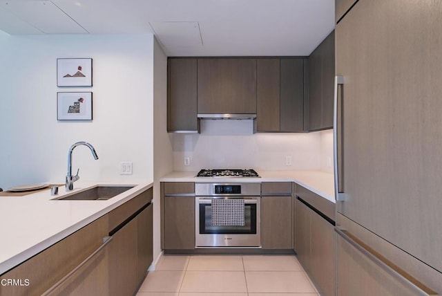 889 Francisco St Unit 802, Los Angeles, CA 90017 - kitchen with appliances with stainless steel finishes, light countertops, under cabinet range hood, and light tile patterned floors