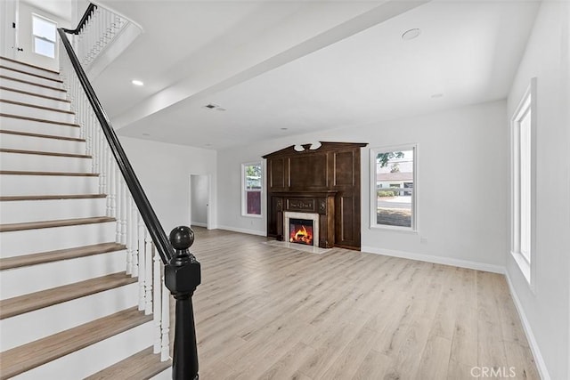12887 Mount Vernon Ave, Grand Terrace, CA 92313 - unfurnished living room with light wood-style flooring, stairs, and a fireplace with flush hearth