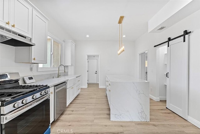 12887 Mount Vernon Ave, Grand Terrace, CA 92313 - kitchen featuring appliances with stainless steel finishes, under cabinet range hood, a barn door, a kitchen island, and white cabinetry