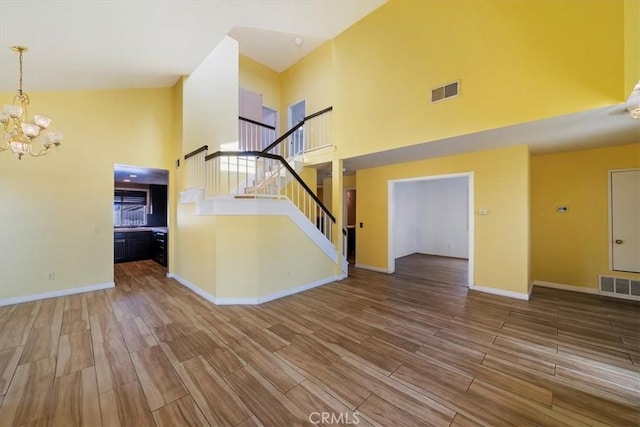 13969 Chervil Ct, Moreno Valley, CA 92553 - unfurnished living room with a high ceiling, wood finished floors, a chandelier, and stairway