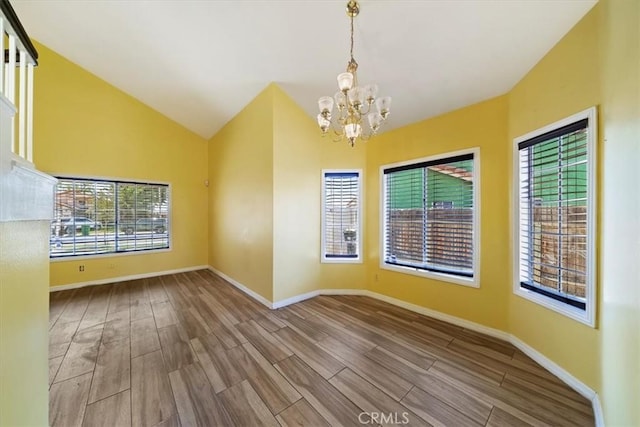 13969 Chervil Ct, Moreno Valley, CA 92553 - empty room featuring a chandelier, healthy amount of natural light, wood finished floors, and vaulted ceiling