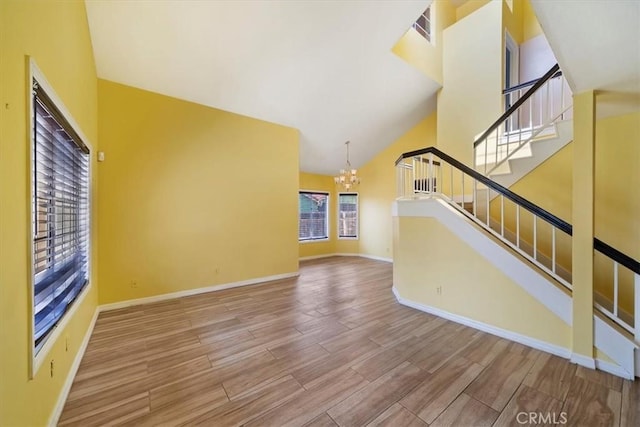 13969 Chervil Ct, Moreno Valley, CA 92553 - unfurnished living room with a chandelier, wood finished floors, stairway, and high vaulted ceiling