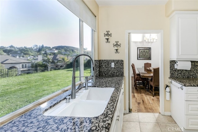 24736 Wooded Vis, West Hills, CA 91307 - kitchen with a chandelier, backsplash, light tile patterned flooring, and white cabinetry