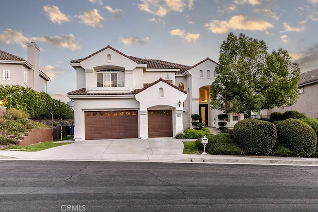 24736 Wooded Vis, West Hills, CA 91307 - mediterranean / spanish home featuring concrete driveway, stucco siding, a tiled roof, and a garage