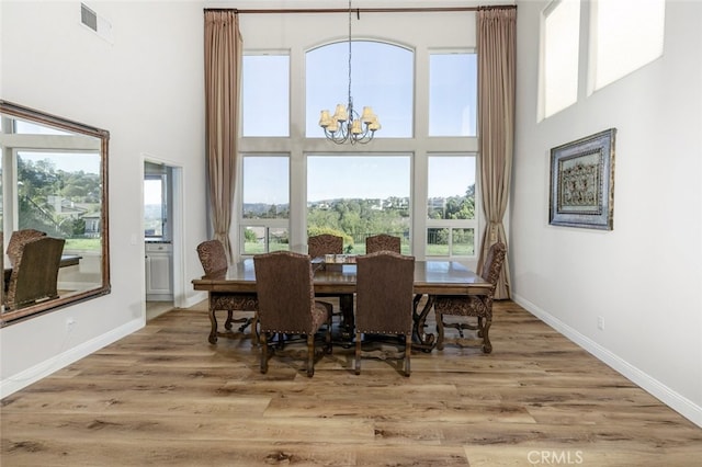 24736 Wooded Vis, West Hills, CA 91307 - dining area featuring a chandelier, a high ceiling, and wood finished floors