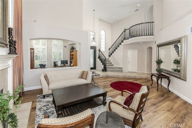 24736 Wooded Vis, West Hills, CA 91307 - living area featuring arched walkways, a high ceiling, stairway, and light wood-type flooring