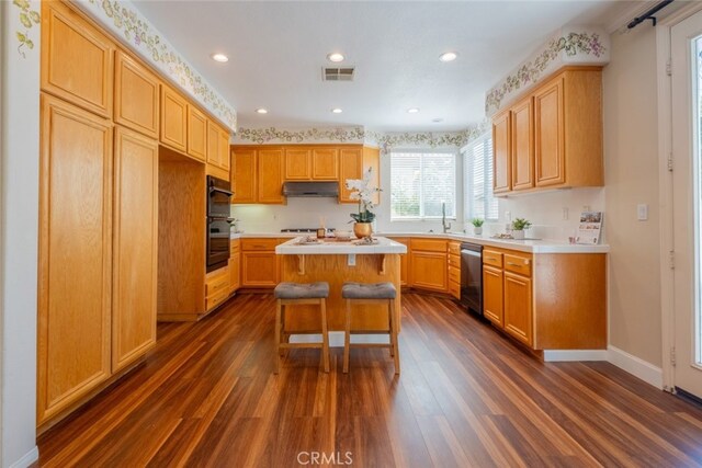 4892 Borders St, Simi Valley, CA 93063 - kitchen featuring stainless steel dishwasher, under cabinet range hood, dark wood-style flooring, light countertops, and recessed lighting