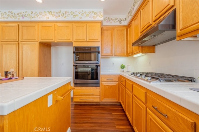 4892 Borders St, Simi Valley, CA 93063 - kitchen featuring under cabinet range hood, tile countertops, appliances with stainless steel finishes, dark wood finished floors, and recessed lighting
