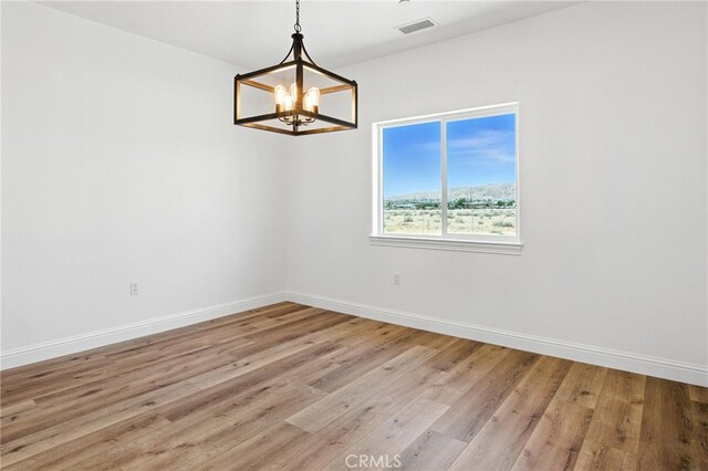 15323 Turquoise Rd, Apple Valley, CA 92307 - unfurnished room with a chandelier and light wood-type flooring