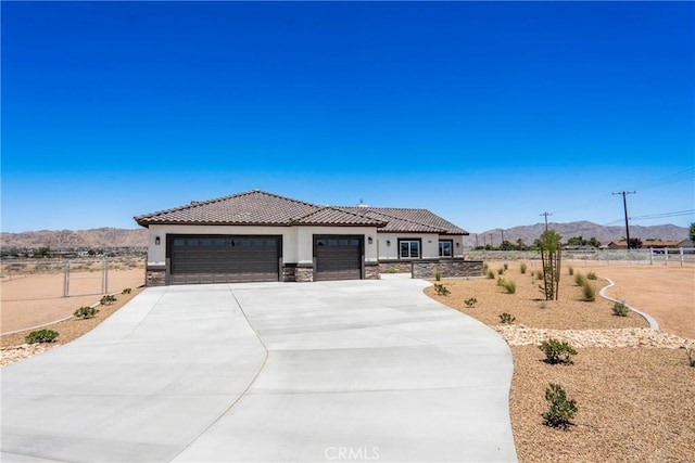 15323 Turquoise Rd, Apple Valley, CA 92307 - view of front of property featuring stucco siding, a mountain view, an attached garage, concrete driveway, and stone siding