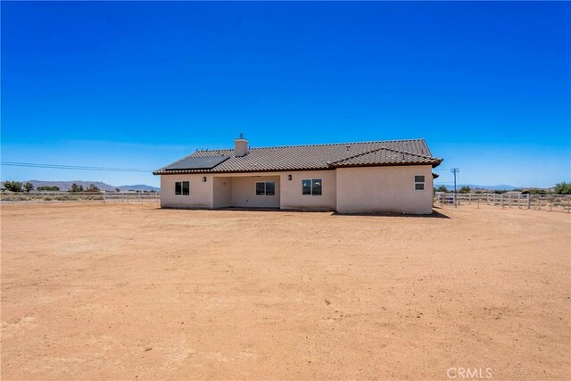 15323 Turquoise Rd, Apple Valley, CA 92307 - back of house with stucco siding, a mountain view, a chimney, a rural view, and a tile roof