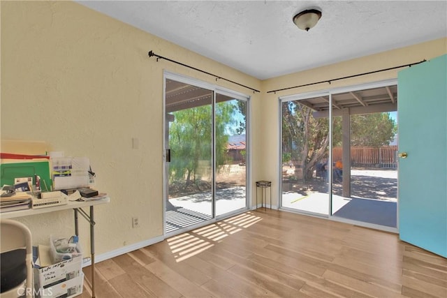 7165 Lyons Ave, Hesperia, CA 92345 - doorway to outside with a textured wall and wood finished floors