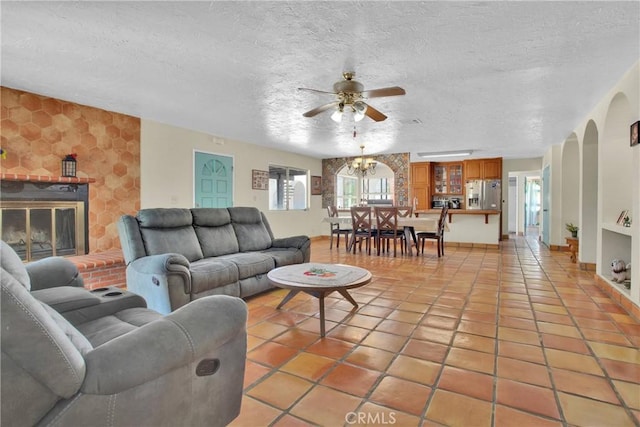 7165 Lyons Ave, Hesperia, CA 92345 - living room with ceiling fan, a textured ceiling, light tile patterned floors, an accent wall, and arched walkways